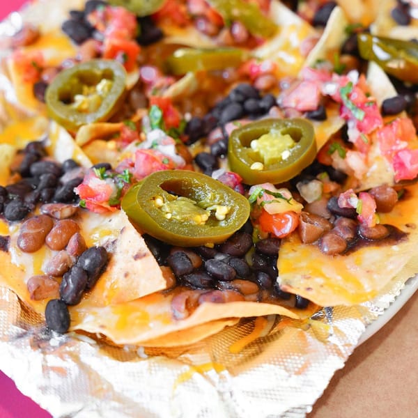 Close-up of Baja Taqueria's nachos with black beans, pinto beans, pico de gallo, and jalapeños.